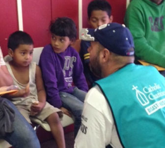 A Catholic Charities representative interviews migrant children at a holding station.