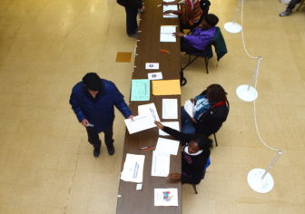 A voter at Hartford Public Library gets his ballot. This was one of several locations that had a delay in getting the voter list.
