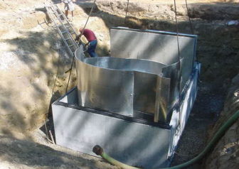 Workers install a special high-tech catch basin to take contamination out of stormwater draining into Coventry Lake in Coventry.