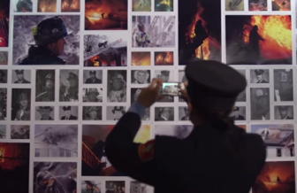 A Boston firefighter photographs a memorial to colleagues who died from cancer.