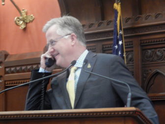 Speaker Brendan Sharkey on the phone from the House podium as the chamber debates budget adjustments late Monday.
