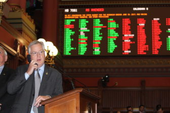 House Speaker J. Brendan Sharkey talks with the majority leader on the phone while the chamber votes on the budget