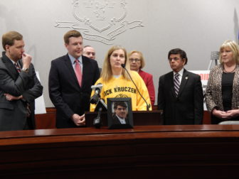 Sue Kruczek, wearing her son Nick's memorial hockey jersey, speaks in favor of a bill to cap the supply of opioid prescriptions. Nick died at age 20 of a heroin overdose after initially taking prescription opioids.