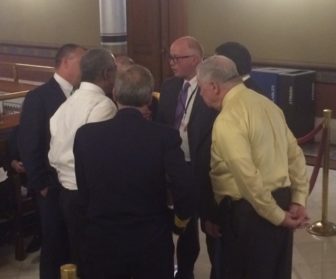 Rick Hart, center, huddling with firefighters and others over a last-minute glitch.