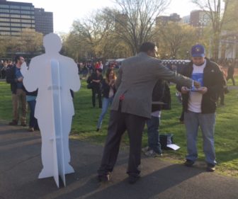 The Rev. John Henry Scott III and a cutout of Bernie Sanders reach out to potential volunteers.