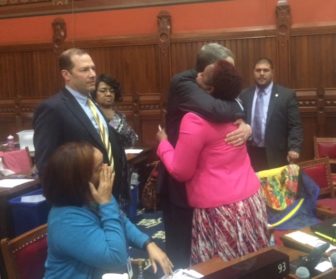 Rep. Robyn Porter, a victim of domestic violence, is hugged by a colleague, Brian Becker, after passage of a domestic violence bill she championed.