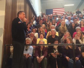 John Kasich shushes the crowd as he sneaks up on Chris Shays.