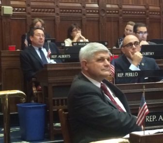 Retiring Reps. Bill Aman, foreground, and Mike Alberts, watching a video tribute.