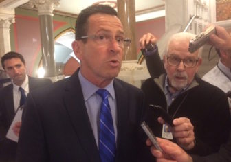 Gov. Dannel P. Malloy is surrounded by reporters after emerging from budget talks with legislative leaders.