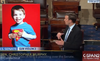 Sen. Chris Murphy displays a poster of Newtown shooting victim Dylan Hockley as he comes to the end of his filibuster on the Senate floor early Thursday.