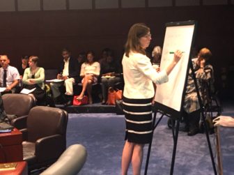 Consultant Megan Burns of Bailit Health writes on a sketchpad during a discussion with the Health Care Cabinet.