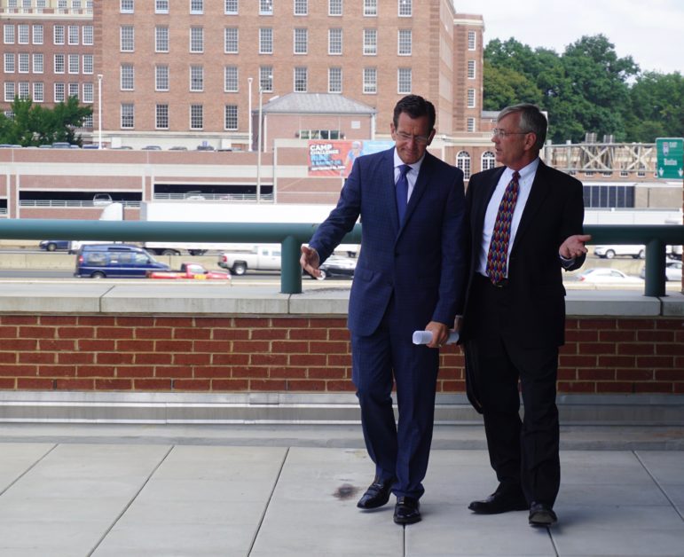 Gov. Dannel P. Malloy and Transportation Commissioner consult before a press conference by the I-84 viaduct.