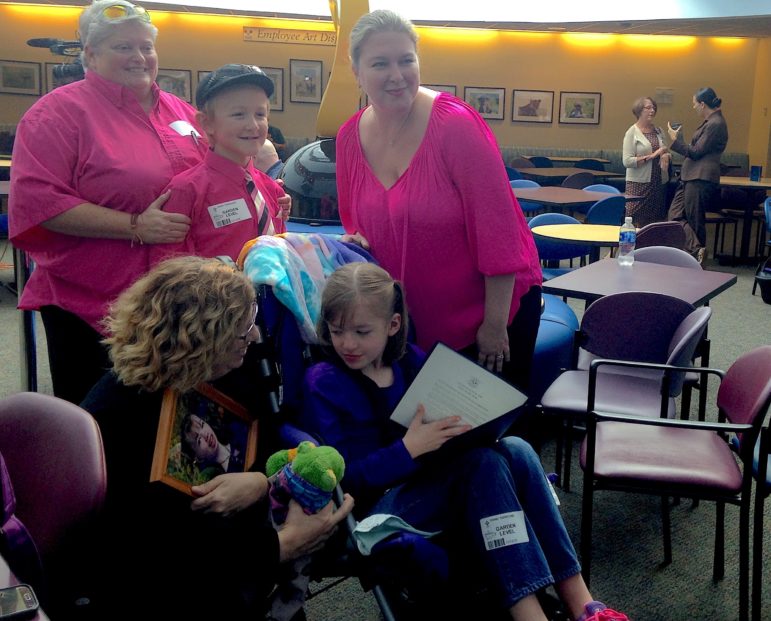 Susan Meehan shows West Tarricone, 8, a photograph of her daughter, Cyndimae, who died in March. Meehan helped inspire the push to legalize medical marijuana for minors in Connecticut. West's parents, Diane and Cara, are applying for West to access it to address her seizures.