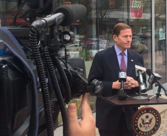 U.S. Sen. Richard Blumenthal at a portable lectern on a sidewalk outside Toy Chest,