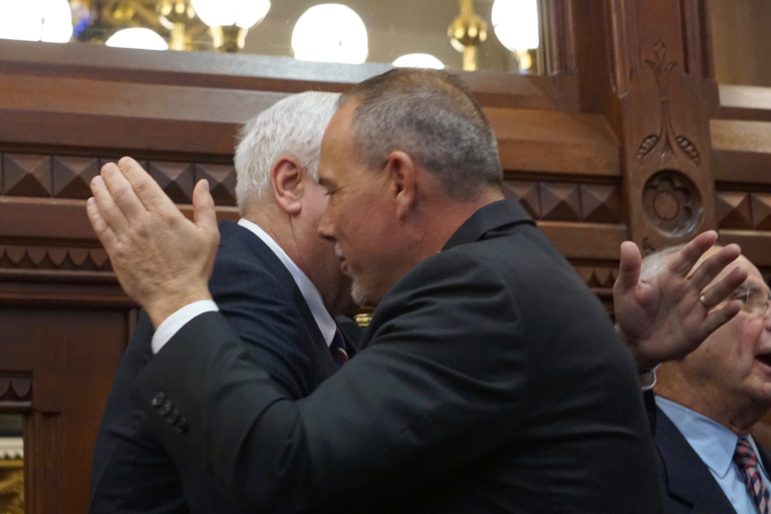 House Speaker Joe Aresimowicz embraces a predecessor, Thomas D. Ritter, the father of House Majority Leader Matt Ritter.