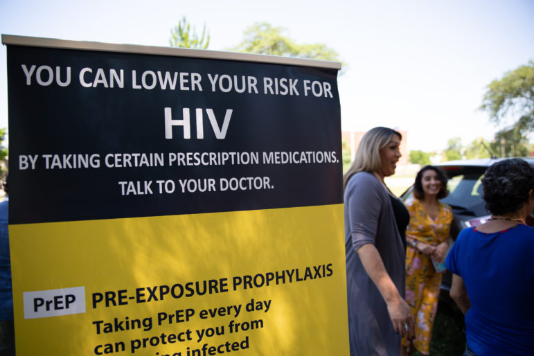 PrEP navigator Tatiana Melendez, standing tall next to the PrEP promotional poster, is doing HIV prevention outreach at Hartford's South Green Park on a recent Friday. Melendez, a.k.a. Lady Tatiana, began working for the Community Renewal Team in May and is trying to reach populations vulnerable to the virus. Photo by Ryan Caron King.