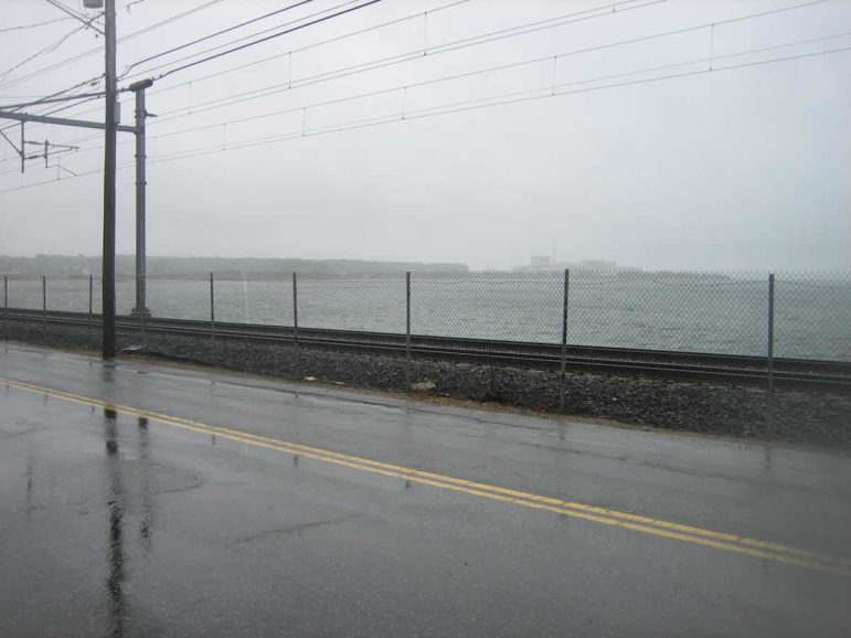 The Amtrak/Shoreline East line in the Niantic section of East Lyme is wedged between the road and Long Island Sound. The Millstone Nuclear Power Station is visible in the background.