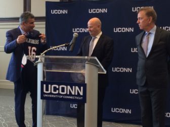 Uconn president-designate Tom Katsouleas accepts a UConn jersey from Uconn Board of Trustees President Tom Kruger and Gov. Ned Lamont