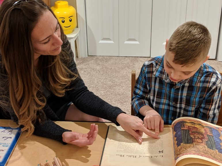 Lina Schlotter helps her son, Tucker, 10, as he reads a biography of Marco Polo. Schlotter homeschools Tucker.