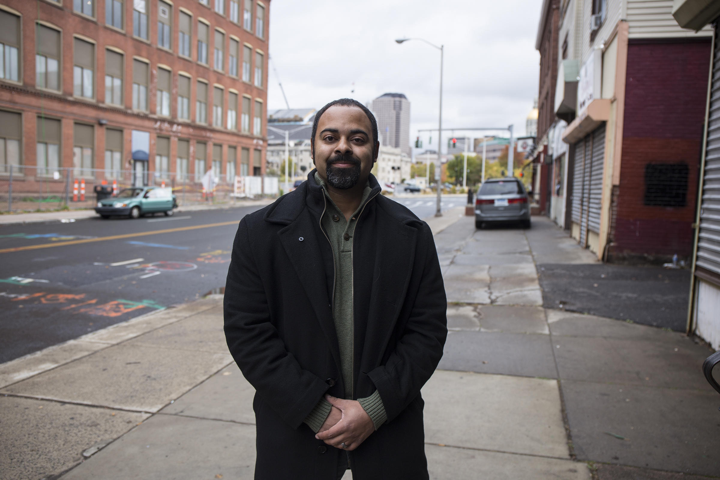 Aaron Gill on the sidewalk outside the building he purchased and renovated with his wife on the edge of the historic Frog Hollow neighborhood in Hartford. Gill is the leader of the local neighborhood advisory board and a member of Hartford's Planning and Zoning Commission.